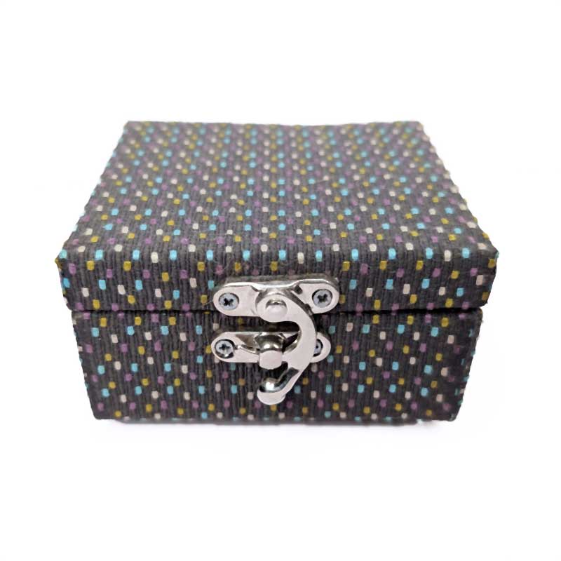 A rectangular fabric-covered storage box with a lid and a silver metal latch closure, featuring a dark charcoal gray woven pattern with small multicolored dots, shown on a plain white background.